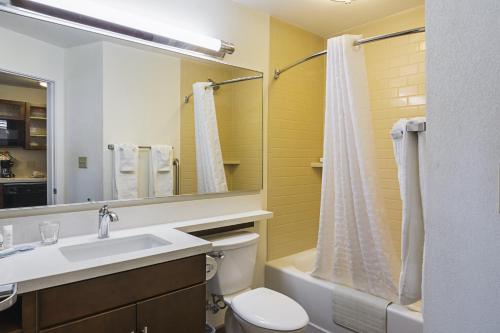 a bathroom with a sink and a toilet and a mirror at Candlewood Suites - Pensacola - University Area, an IHG Hotel in Pensacola