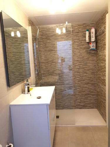 a bathroom with a shower with a sink and a mirror at GARDEN 128 in Corralejo