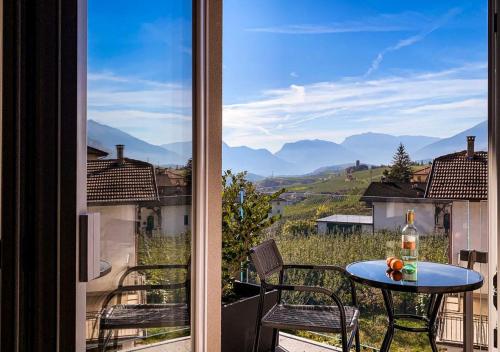 a table and chairs on a balcony with a view at Orizzonti d'Anaunia in Tassullo