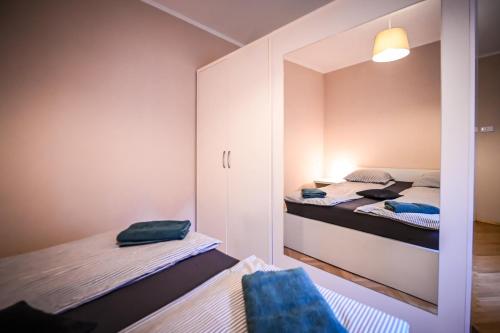 シビウにあるJules' sunny, spacious and central apartmentの小さなベッドルーム(ベッド2台、鏡付)