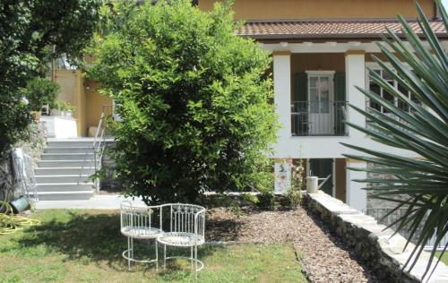two chairs sitting in the grass in front of a house at Residenza La Zagara in Cannero Riviera