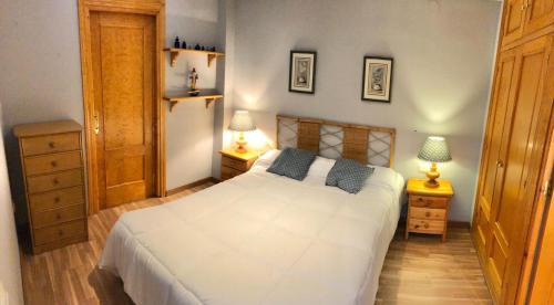 een slaapkamer met een wit bed en twee nachtkastjes bij LUXURY GINEBRA in Sierra Nevada