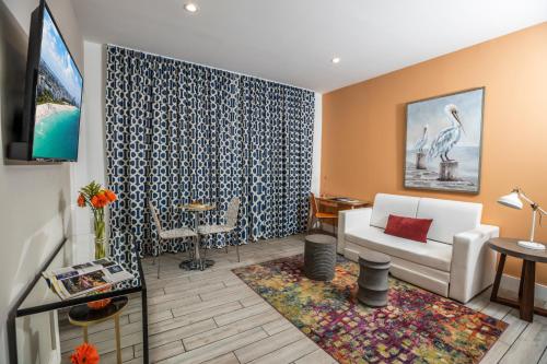 een woonkamer met een bank en een tv bij Oceanside Hotel and Suites in Miami Beach