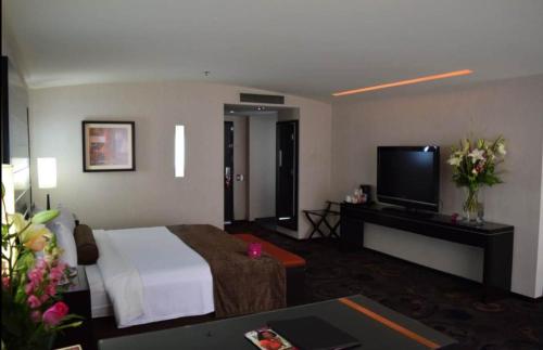 a hotel room with a bed and a flat screen tv at Crowne Plaza Toluca - Lancaster by IHG in Toluca
