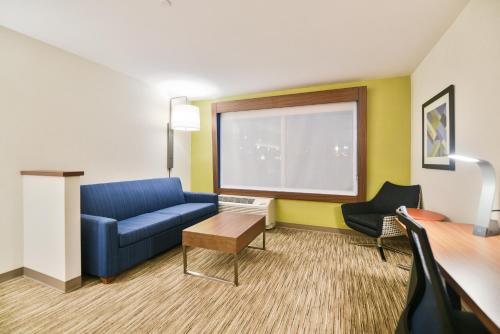 a living room with a blue couch and a chair at Holiday Inn Express & Suites Lehi - Thanksgiving Point by IHG in Lehi