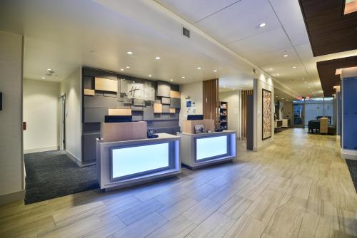 an office lobby with two monitors on the wall at Holiday Inn Express & Suites Lehi - Thanksgiving Point by IHG in Lehi