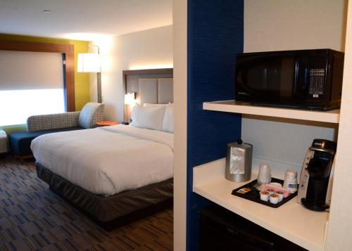 a hotel room with a bed and a television at Holiday Inn Express & Suites - Pittsburgh - Monroeville by IHG in Monroeville