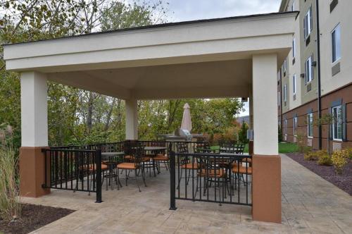 a patio with tables and chairs under a pavilion at Candlewood Suites Sayre by IHG in Sayre