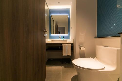 a bathroom with a toilet and a sink with a mirror at Holiday Inn Express Shanghai Tangzhen by IHG - 20 mins to PVG Airport and Disney land in Shanghai