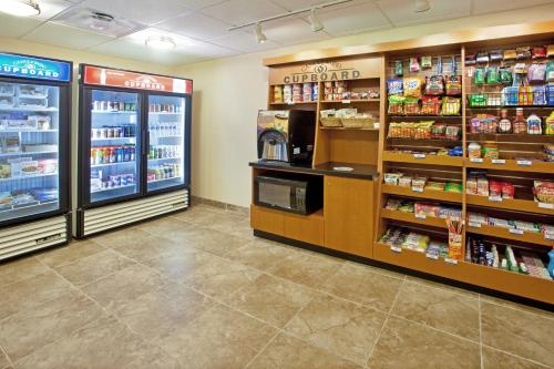 a store aisle with refrigerators and shelves of food at Candlewood Suites Roswell by IHG in Roswell