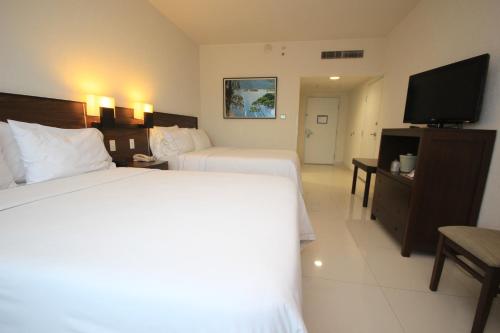 a hotel room with two beds and a flat screen tv at Holiday Inn Express Tuxtla Gutierrez La Marimba by IHG in Tuxtla Gutiérrez