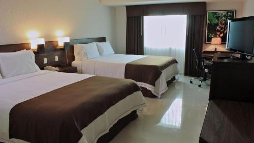 a hotel room with two beds and a television at Holiday Inn Express Tuxtla Gutierrez La Marimba by IHG in Tuxtla Gutiérrez