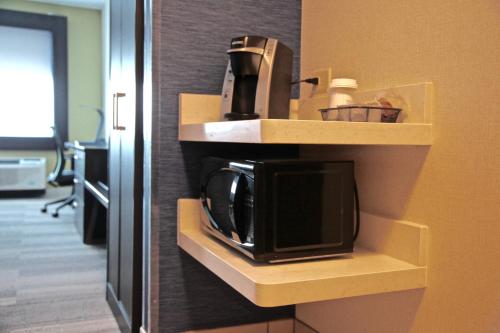 a microwave sitting on a shelf in a hotel room at Holiday Inn Express & Suites Oswego by IHG in Oswego