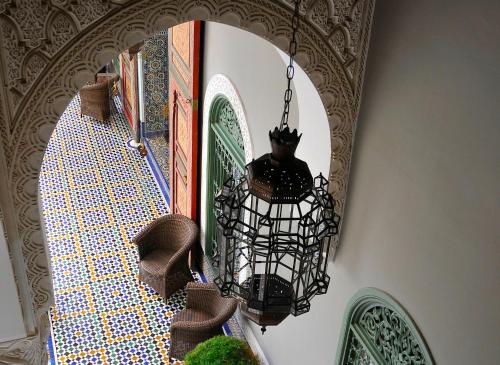 a black chandelier hanging from a wall with a mirror at Palais Faraj Suites & Spa in Fès