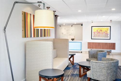 a waiting room with a couch and chairs and tables at Holiday Inn Express Sheboygan-Kohler / I-43 by IHG in Sheboygan