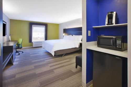 a hotel room with a bed and a tv at Holiday Inn Express Tiffin, an IHG Hotel in Tiffin