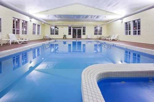 ein großer Pool mit blauem Wasser in einem Gebäude in der Unterkunft Holiday Inn Express St Ignace-Lake Central, an IHG Hotel in Saint Ignace