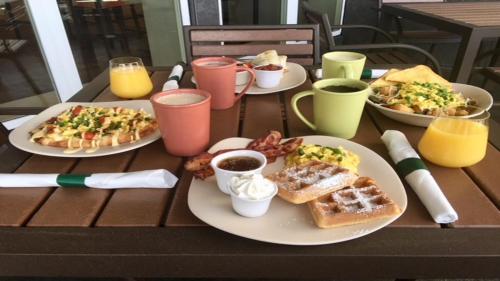 a table with plates of breakfast foods and drinks at Holiday Inn Tacoma Mall by IHG in Tacoma