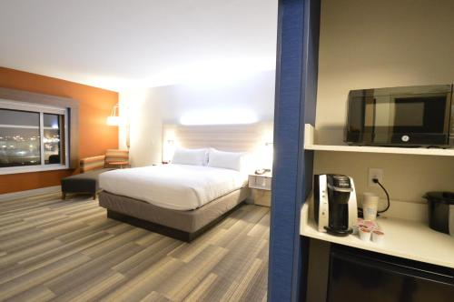 Perrysburg HeightsにあるHoliday Inn Express & Suites Toledo South - Perrysburg, an IHG Hotelのベッド1台、薄型テレビが備わるホテルルームです。