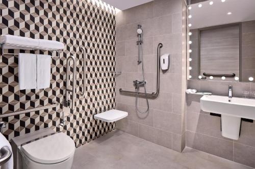 a bathroom with a shower and a toilet and a sink at Holiday Inn Express Singapore Serangoon, an IHG Hotel in Singapore