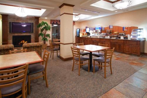 ソルトレイクシティにあるHoliday Inn Express Airport East, an IHG Hotelのテーブルと椅子、暖炉のあるレストラン