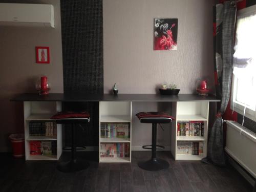 a table and two stools in a room with books at Chambre d'Hôtes Hola in Laval