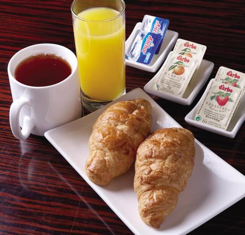 a plate with two croissants and a cup of orange juice at Holiday Inn Express Jinan High-Tech Zone by IHG in Jinan