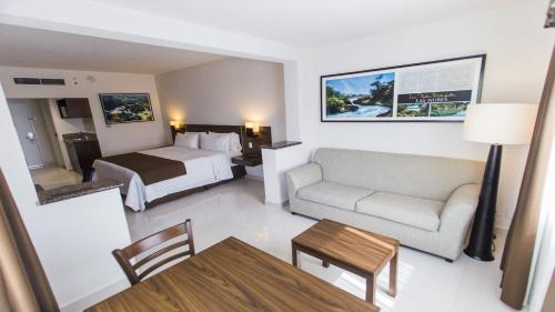 a hotel room with a bed and a couch and a table at Holiday Inn Express Tuxtla Gutierrez La Marimba, an IHG Hotel in Tuxtla Gutiérrez