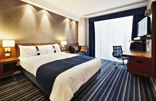 a hotel room with a large bed and a desk at Holiday Inn Express Madrid Leganes by IHG in Leganés