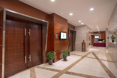 a lobby with wooden doors and potted plants at Holiday Inn Shanghai Hongqiao Central by IHG in Shanghai