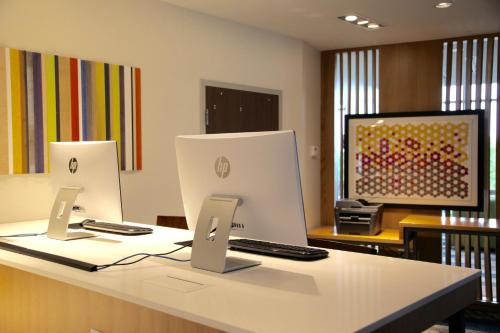 an office with a desk with two computers on it at Holiday Inn Express & Suites Oswego by IHG in Oswego