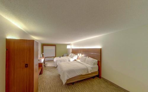 a hotel room with two beds and a mirror at Holiday Inn Express Fort Wayne - East - New Haven by IHG in New Haven
