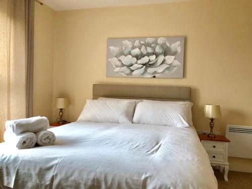 a bedroom with a white bed with towels on it at The Paramount, Swindon in Swindon