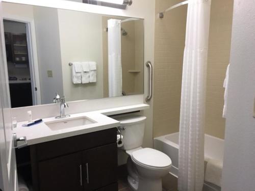 een badkamer met een toilet, een wastafel en een douche bij Candlewood Suites - East Syracuse - Carrier Circle, an IHG Hotel in East Syracuse