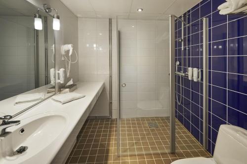 a bathroom with a sink and a shower at Holiday Inn Tampere - Central Station by IHG in Tampere