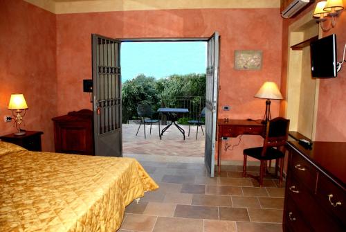 a bedroom with a bed and a door leading to a patio at Agriturismo Casacchella in San Nico