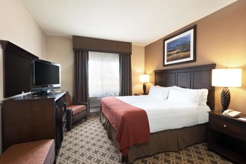 a hotel room with a bed and a flat screen tv at Holiday Inn Express Show Low by IHG in Show Low