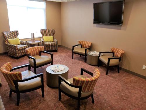 a waiting room with chairs and tables and a flat screen tv at Holiday Inn Express Portland West/Hillsboro by IHG in Hillsboro