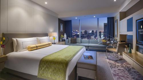 a bedroom with a large bed and a living room at InterContinental Shanghai Jing' An by IHG in Shanghai