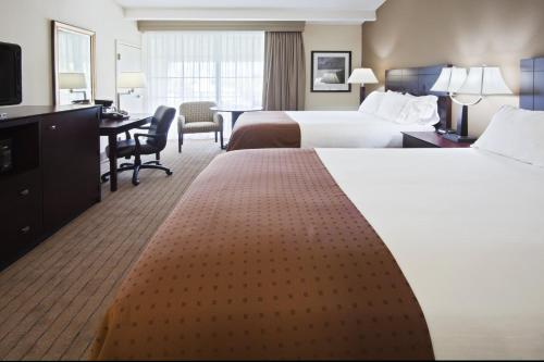 a hotel room with two beds and a desk at Holiday Inn Express- North Palm Beach and IHG Hotel in Juno Beach