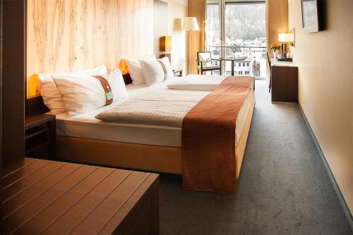 a hotel room with a bed and a table at Holiday Inn - Salzburg City by IHG in Salzburg