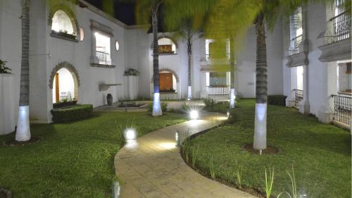 a courtyard of a building with palm trees and lights at Holiday Inn Express Morelia by IHG in Morelia