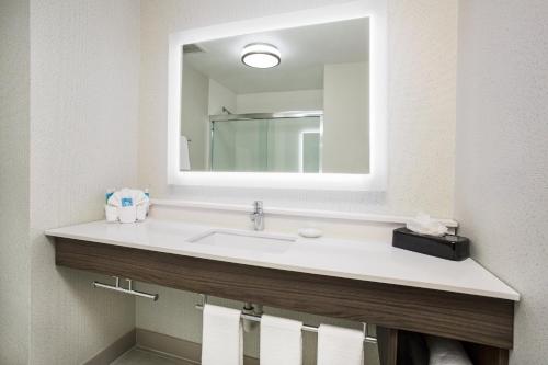 a bathroom with a sink and a large mirror at Holiday Inn Express Kansas City - at the Legends! by IHG in Kansas City