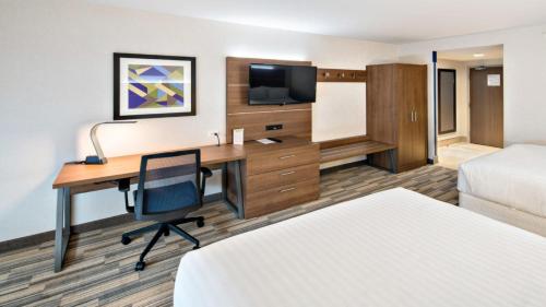 ein Hotelzimmer mit einem Schreibtisch und einem Bett in der Unterkunft Holiday Inn Express Hotel & Suites Mount Pleasant, an IHG Hotel in Mount Pleasant