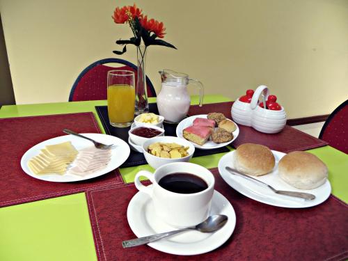 a table with plates of food and a cup of coffee at Hotel Newen in Temuco