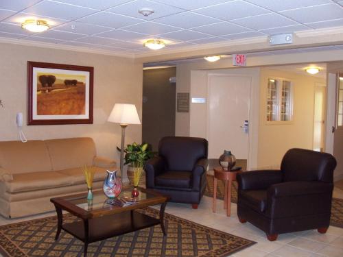 a waiting room with two chairs and a couch and a table at Candlewood Suites Olive Branch by IHG in Olive Branch
