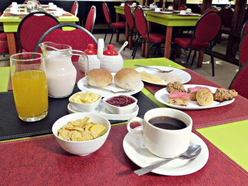 a table topped with plates of food and cups of coffee at Hotel Newen in Temuco
