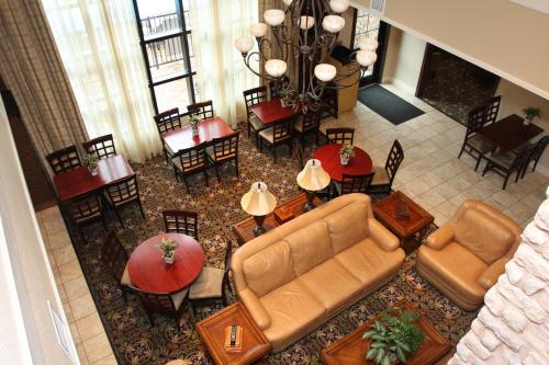 a living room with a couch and tables and chairs at Staybridge Suites McAllen by IHG in McAllen