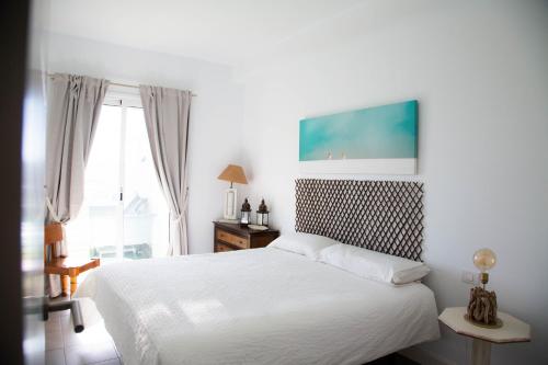 1 dormitorio con cama blanca y ventana en Vistas al Mar junto a la playa 3B en Poris de Abona