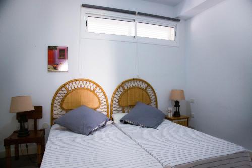 a bedroom with a bed with two pillows and a window at Vistas al Mar junto a la playa 3B in Poris de Abona